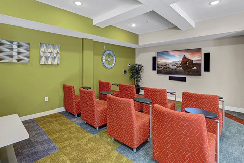 a waiting room with orange chairs and green walls