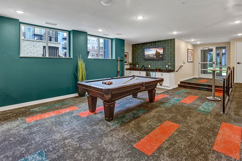 a game room with a pool table and a tv