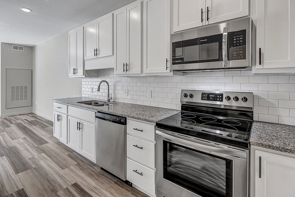 a kitchen with white cabinets and stainless steel appliances