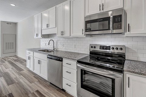 a kitchen with white cabinets and stainless steel appliances