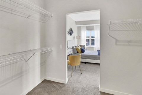 a bedroom with a closet and two hanging racks on the wall