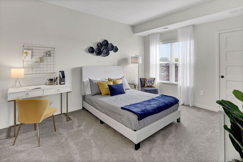 a bedroom with a bed and a desk with a chair