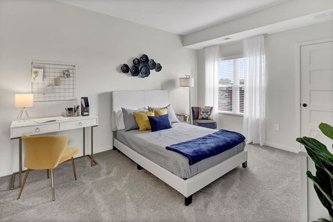 a bedroom with a bed and a desk with a chair