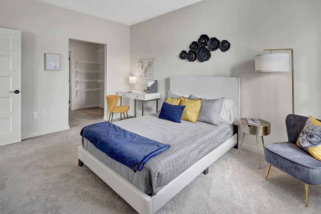 a bedroom with a bed and a desk and a chair