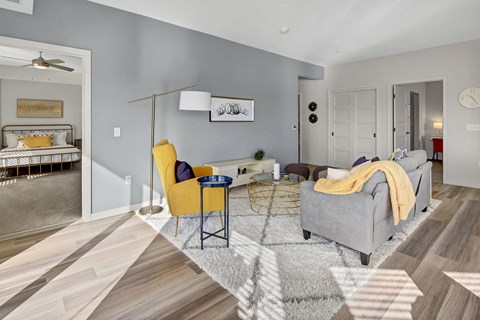 a living room with a gray couch and yellow chairs