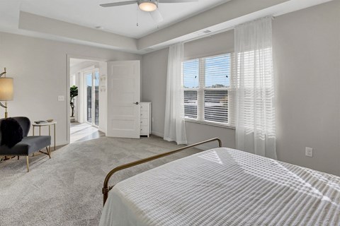 a bedroom with a bed and a window with white blinds
