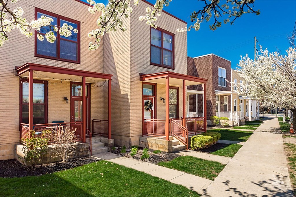A row of houses with red doors and windows.