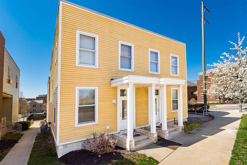 A yellow house with white trim and a front porch.