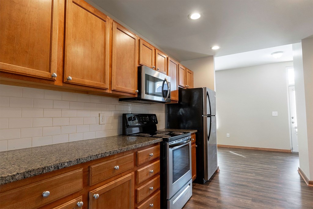 A kitchen with wooden cabinets and black appliances.
