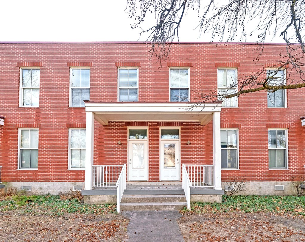 A red brick building with a white door and windows.