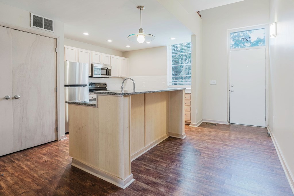 A kitchen with a refrigerator, microwave, and oven.