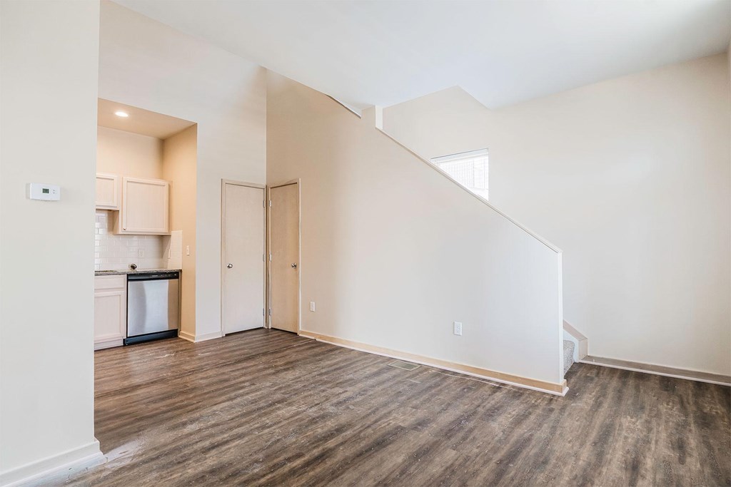 A kitchen with a refrigerator, cabinets, and a countertop is visible through a doorway.