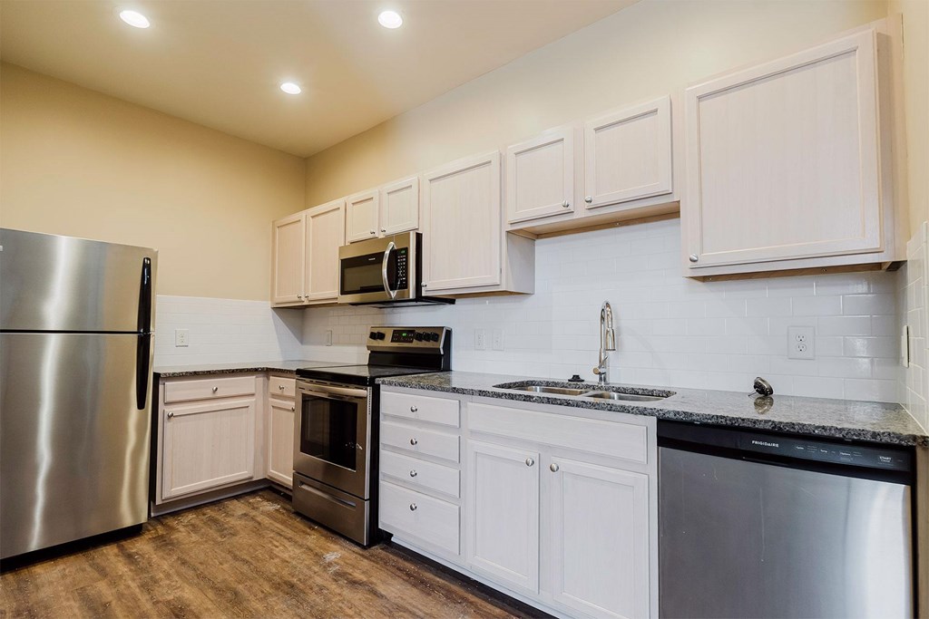 A kitchen with white cabinets and stainless steel appliances.