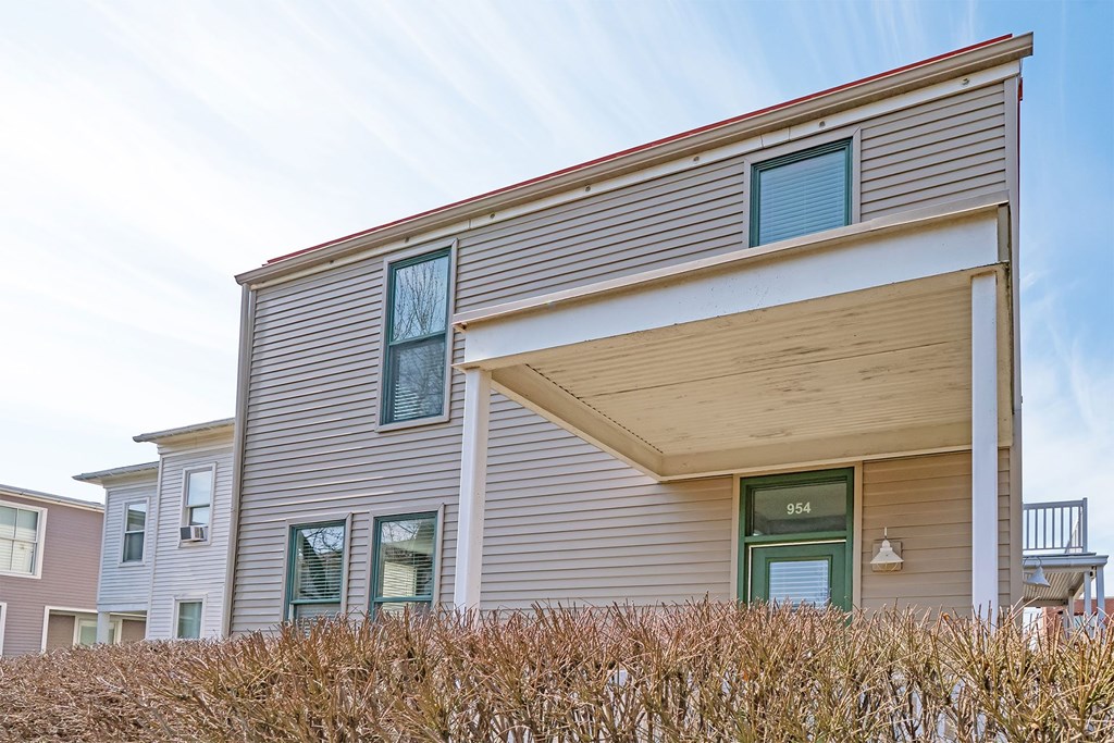 A modern house with a grey facade and a green door.