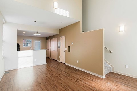 A spacious room with wooden floors and white walls.