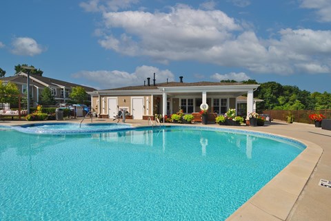 A large swimming pool in front of a house.