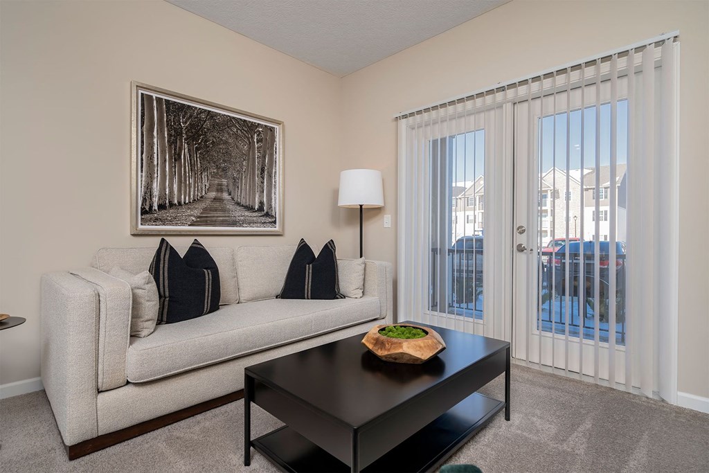 A living room with a couch, coffee table, and a picture on the wall.
