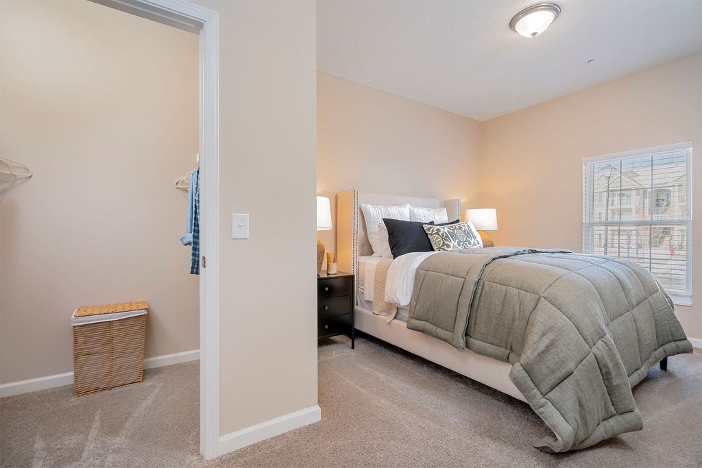 A bedroom with a large bed and a window.