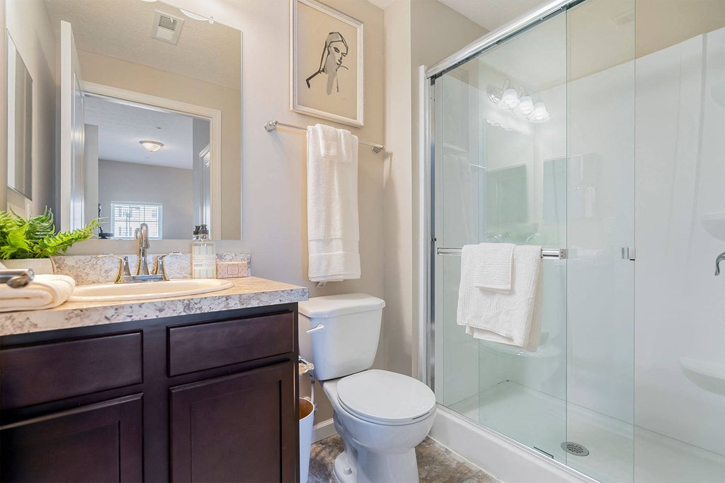 A bathroom with a toilet, sink, and shower.