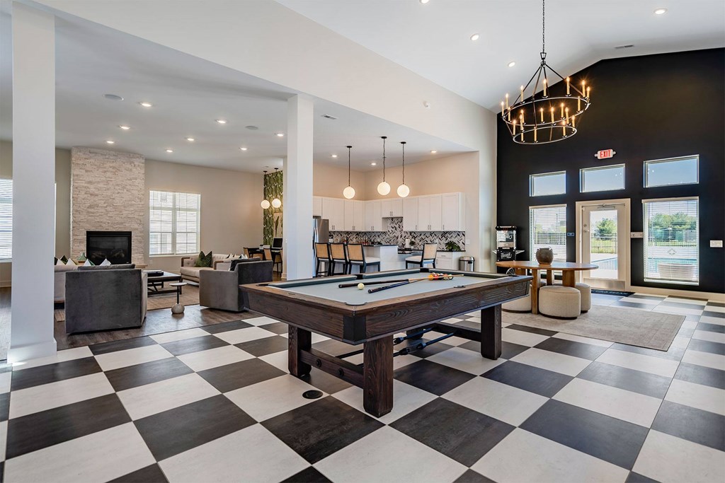 A black and white checkered floor in a spacious room with a pool table.
