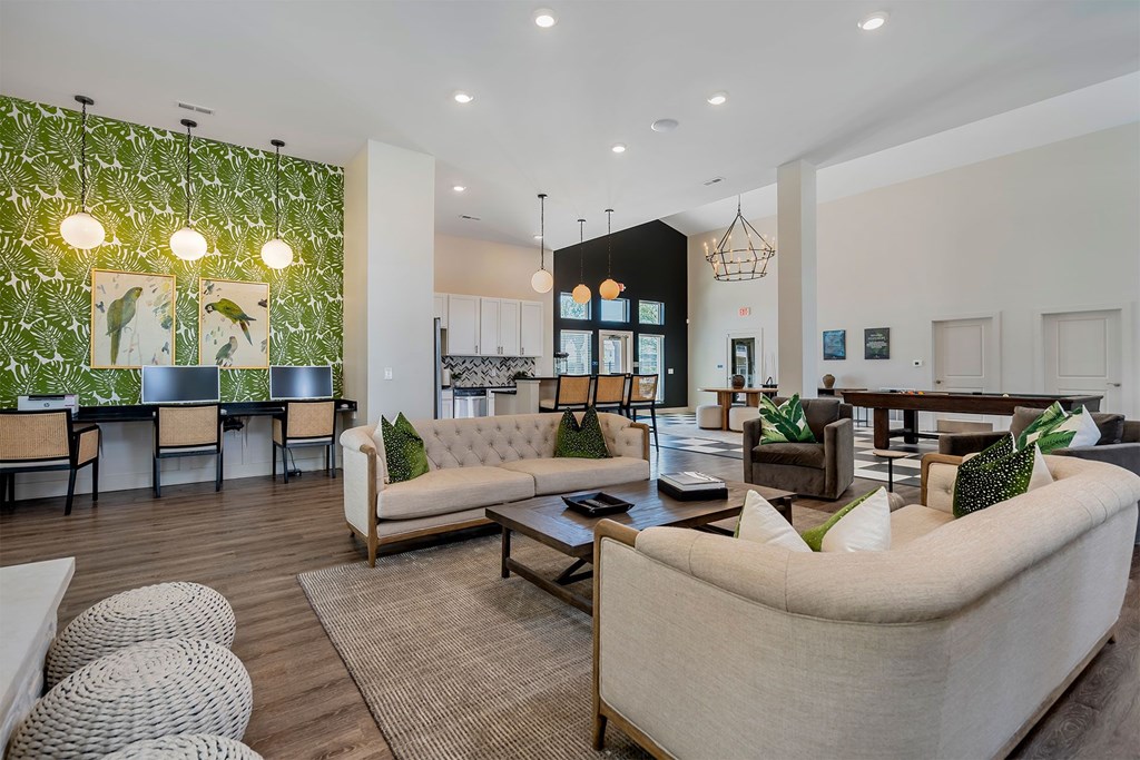 A living room with a white couch and a green plant on the wall.