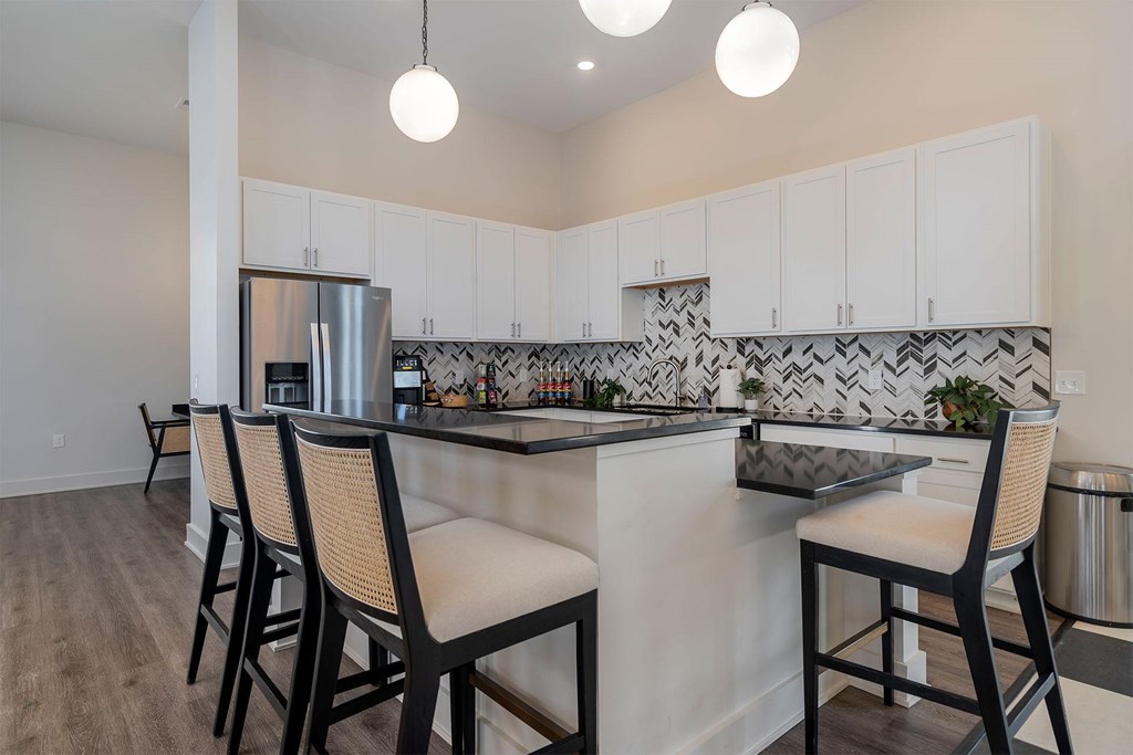 A kitchen with a bar area and chairs.