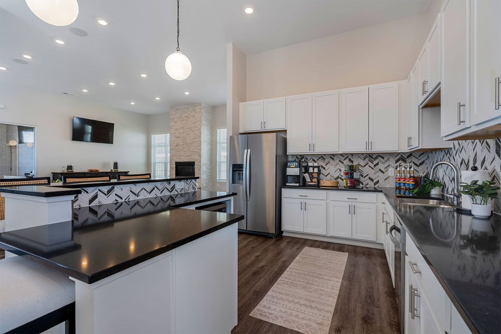 A modern kitchen with a black countertop and white cabinets.