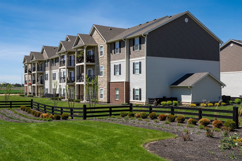 A row of houses with a green lawn in front.
