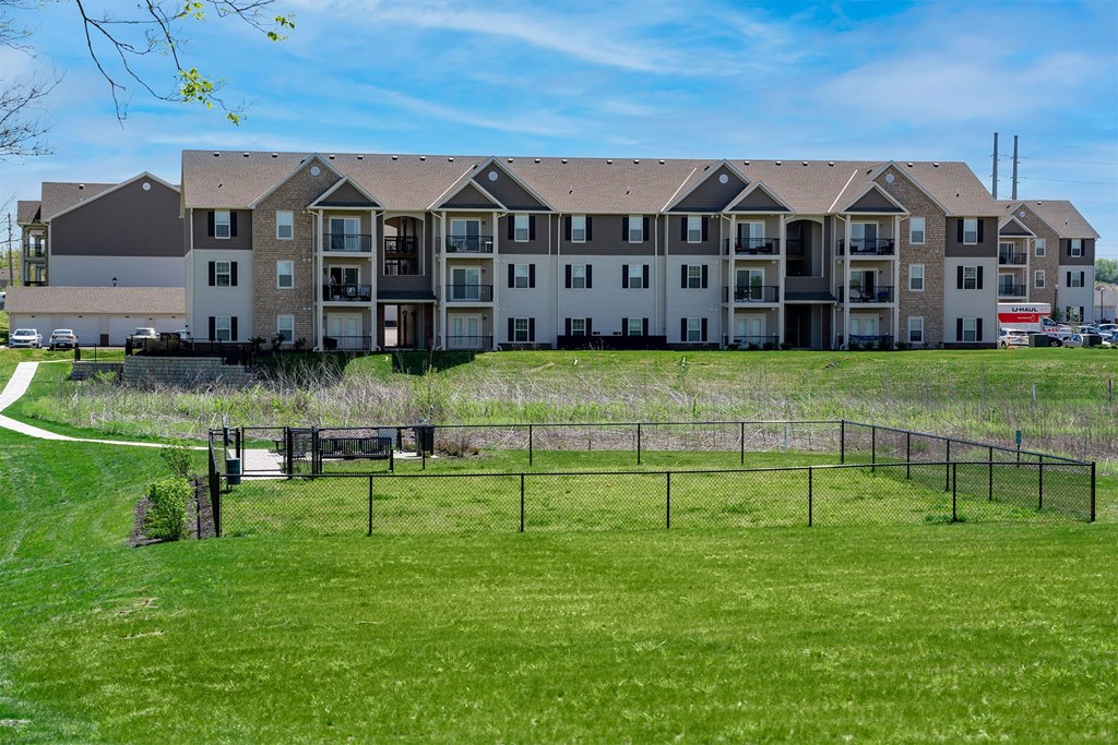 A large apartment complex with a grassy area in front.