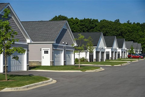 A row of houses with garages and driveways.