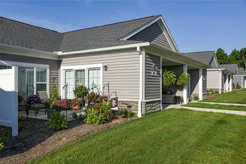 A house with a grey roof and a white fence.