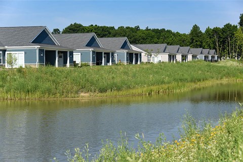 A row of houses with a body of water in front.