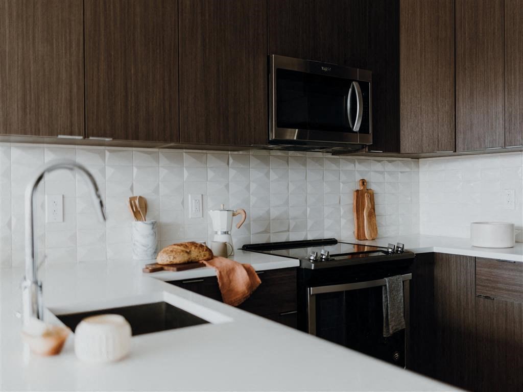 a kitchen with a sink a stove and a microwave