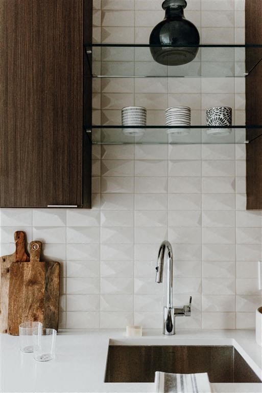a kitchen sink with a glass shelf above it