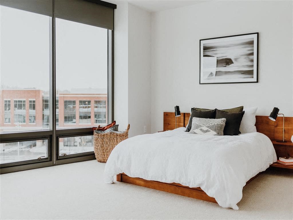 a bedroom with a large bed next to a window