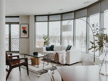 a living room with large windows and a white couch