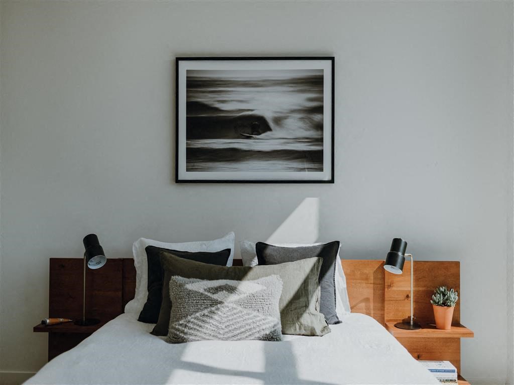 a bedroom with a large painting above the bed