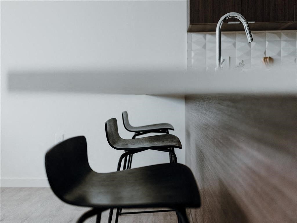 a couple of black chairs sitting next to a sink