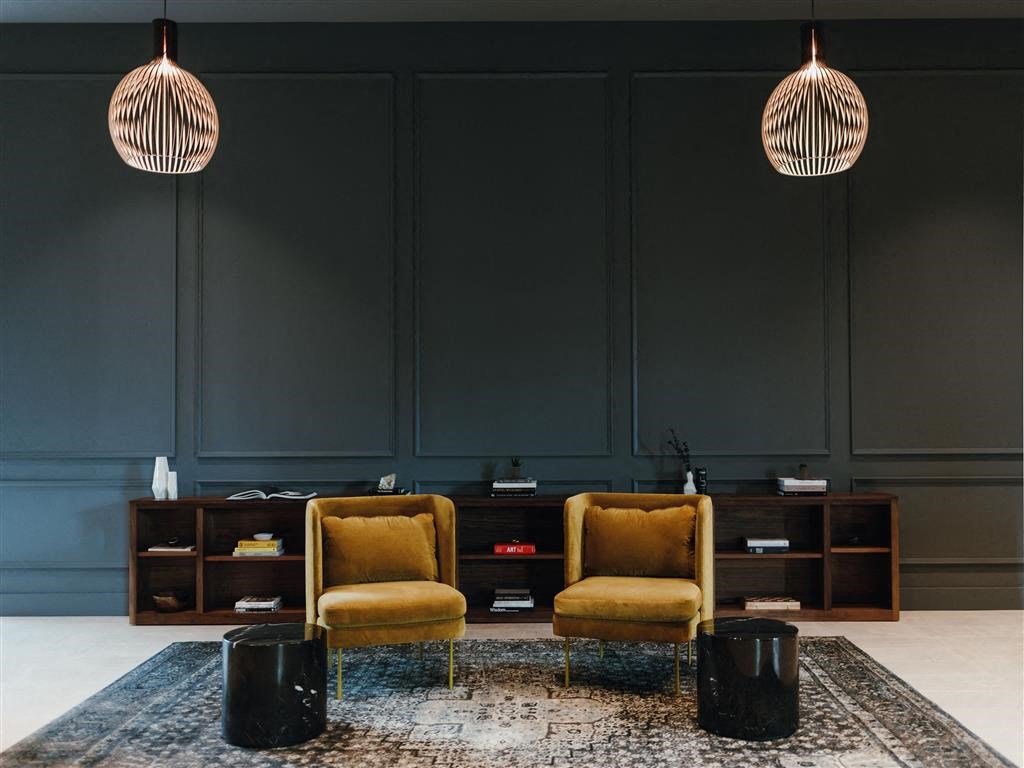 a room with two yellow chairs and a rug