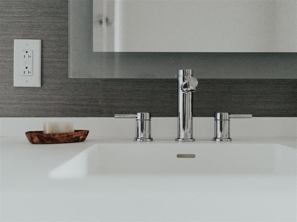 a sink with a faucet and a bowl with a candle on it