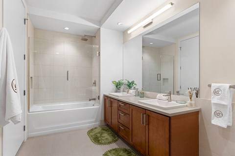 A bathroom with a white tub, sink, and towel rack.