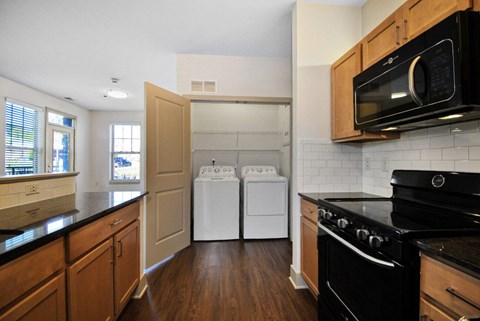 A kitchen with a black stove and white dishwasher.
