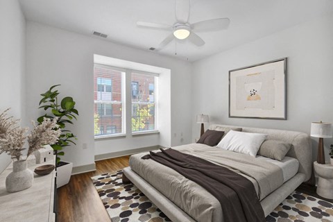 A bedroom with a large bed and a ceiling fan.