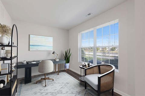 A room with a desk, chair, and a painting on the wall.