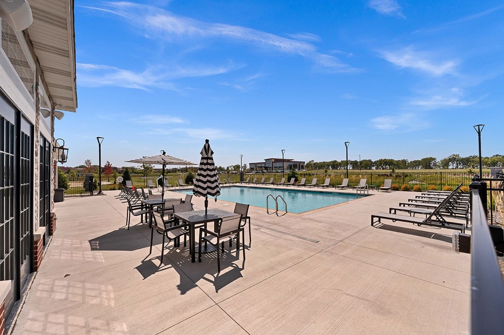 A pool area with a table and chairs.