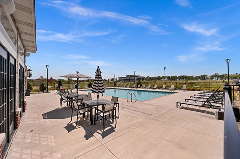 A pool area with a table and chairs.