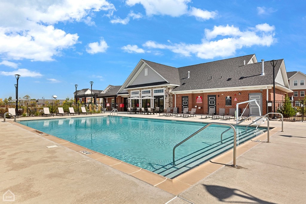 A large swimming pool in front of a building with a red brick exterior.