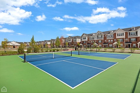 A tennis court with a net and a green surface.