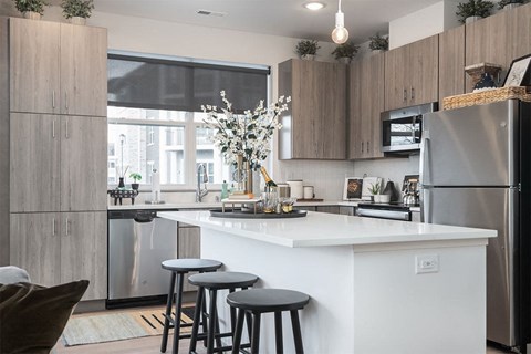 a kitchen with a counter and three stools
