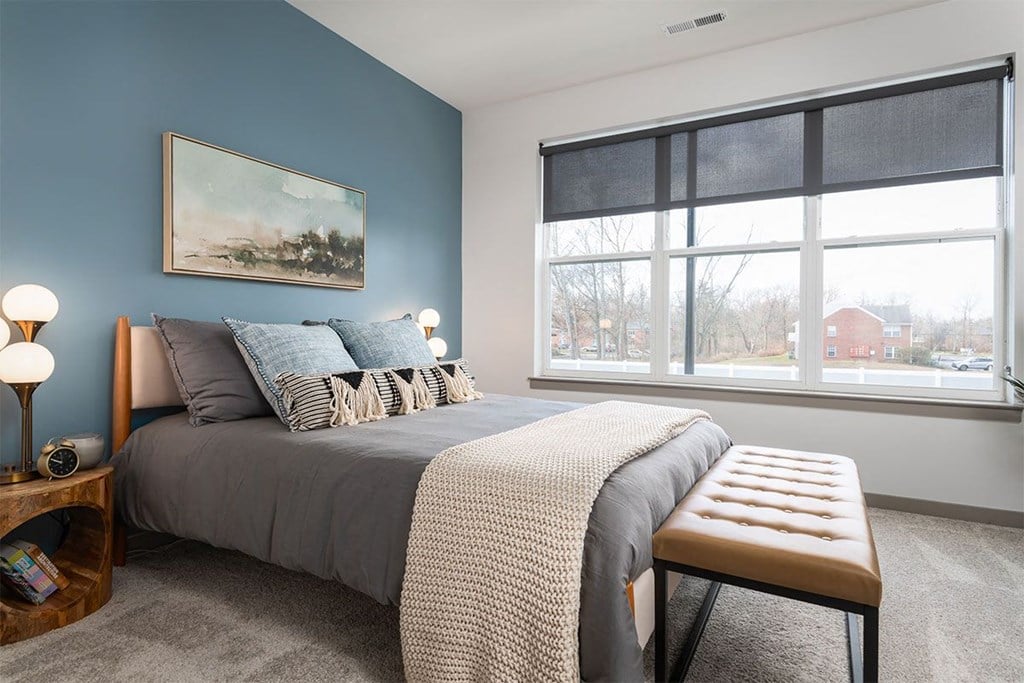 a bedroom with a bed and a large window